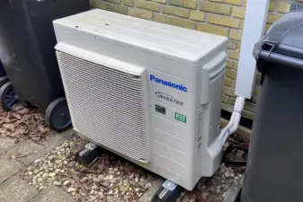 Panasonic varmepumpe placeret mellem skraldespande
