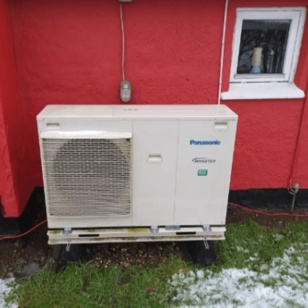 Panasonic varmepumpe ved rødt hus